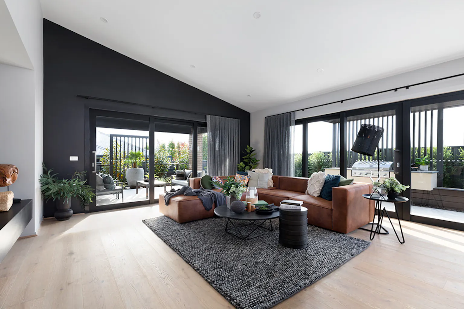18. The open plan living area in the Delta design uses a stylish dark feature wall
